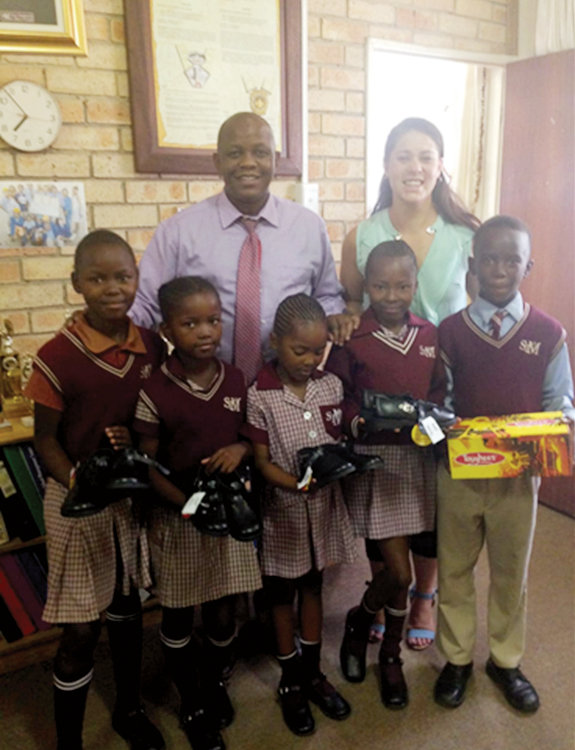 THANK YOU–St. Mary’s Primary School principal Victor Sekakatlela and teacher Lesly Beylefeld give out school uniforms in this photo shared with Iona Prep’s Human Rights Club in New Rochelle to thank the club for money raised to pay for student tuition and uniform fees to attend the school in Bloemfontein, South Africa.