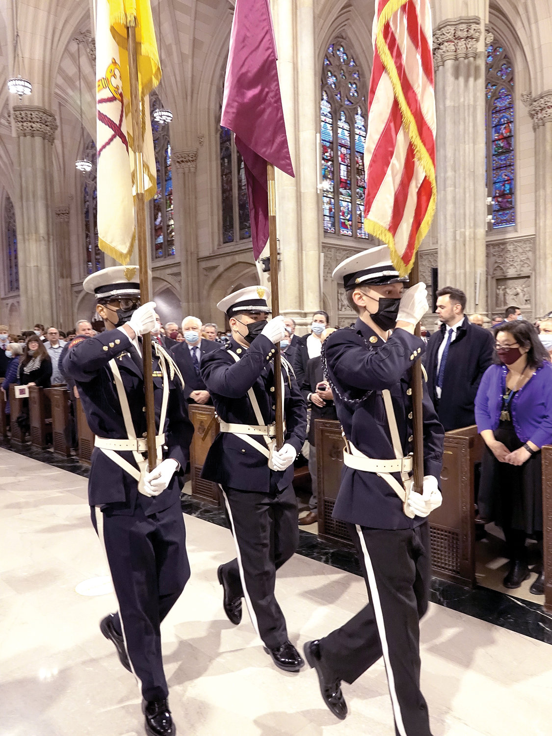 Three student members of the Junior Reserve Officers Training Corps lead the procession at the start of Mass.