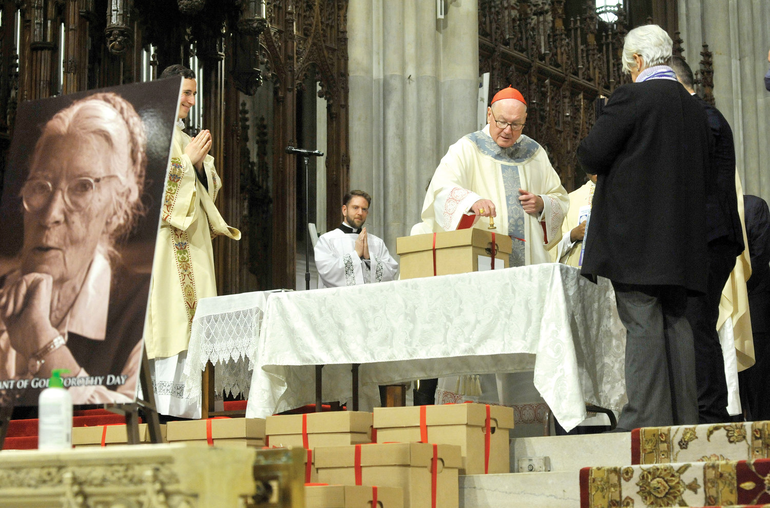 Cardinal Dolan stamps a heated wax seal atop a ribbon on a box, marking the conclusion of the diocesan phase of the canonization cause for Servant of God Dorothy Day during Mass he celebrated Dec. 8 at St. Patrick’s Cathedral.