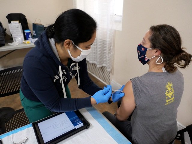 A nurse from the Community Healthcare Network administers a Covid-19 vaccine Dec. 19 in the rectory of St. Elizabeth parish in the Washington Heights section of Manhattan.