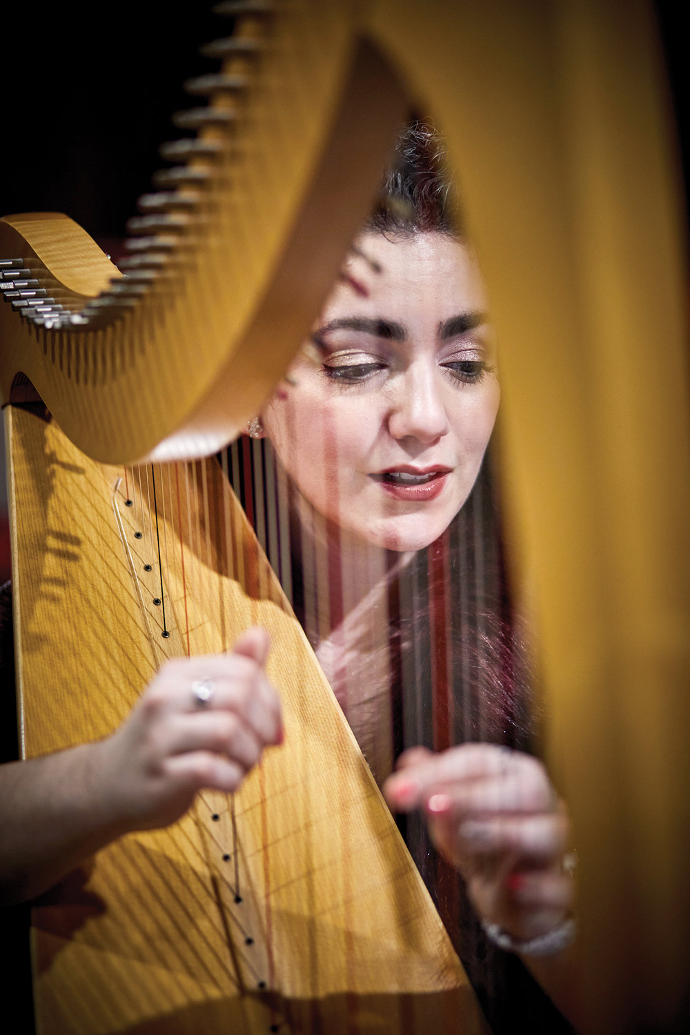 Christa Dalmazio plucks harp Jan. 5 as guest musician and singer at the first monthly Young Adult Mass of 2022 in St. Patrick's Cathedral. Father Jean-Paul Soler, the celebrant, told the young adults how a morning holy hour as a seminarian became a key spiritual measure in his daily life.