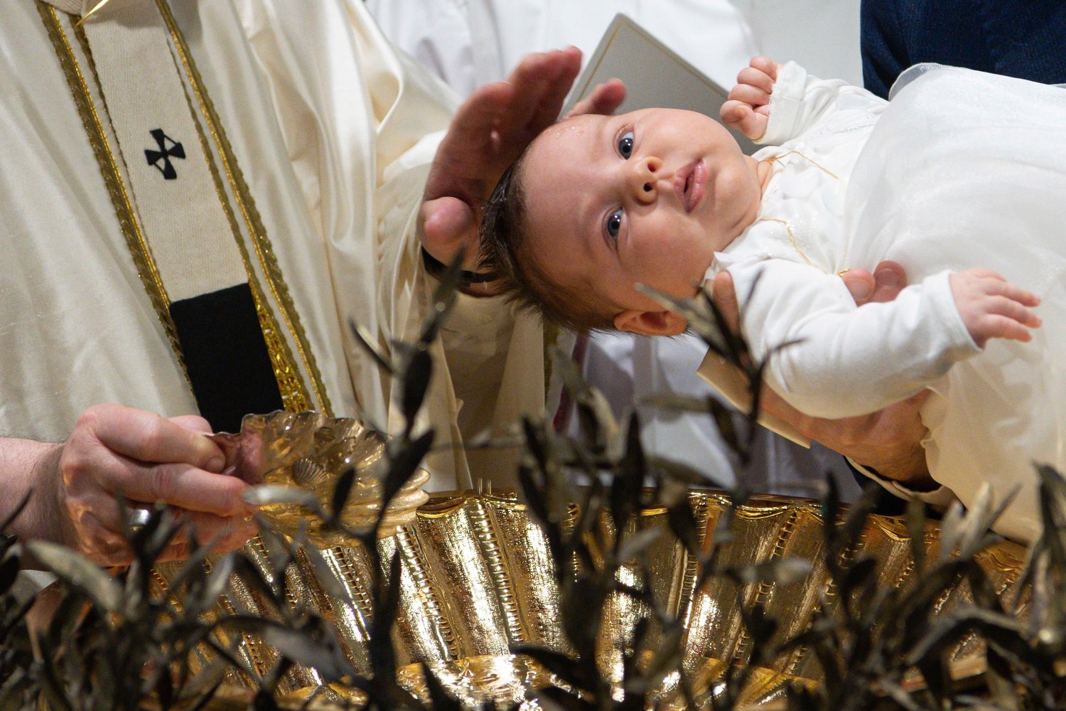 Pope Francis baptizes a baby as he celebrates Mass marking the feast of the Baptism of the Lord in the Sistine Chapel at the Vatican Jan. 9. The pope baptized 16 infants.