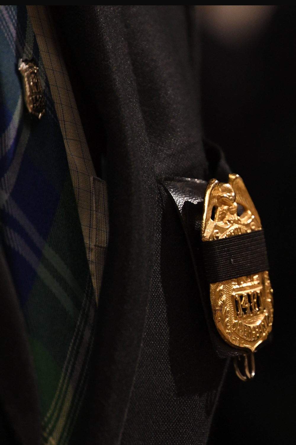 A badge cloaked in black is worn by a congregant.
