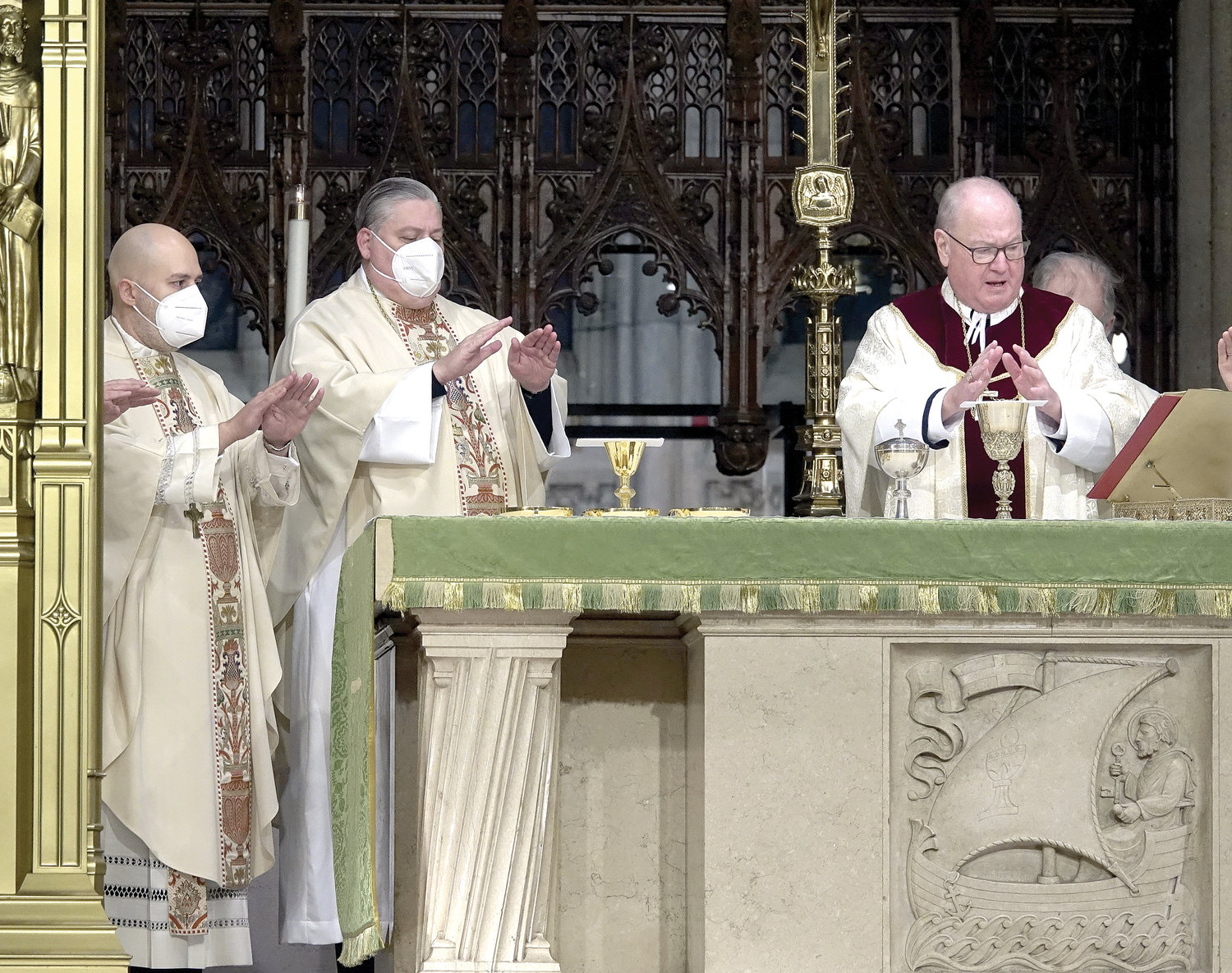 Bishop-elect Joseph Espaillat and Bishop-elect John Bonnici pray with Cardinal Dolan during morning Mass at St. Patrick’s Cathedral Jan. 25, the day their appointments as new auxiliary bishops for the archdiocese were announced.