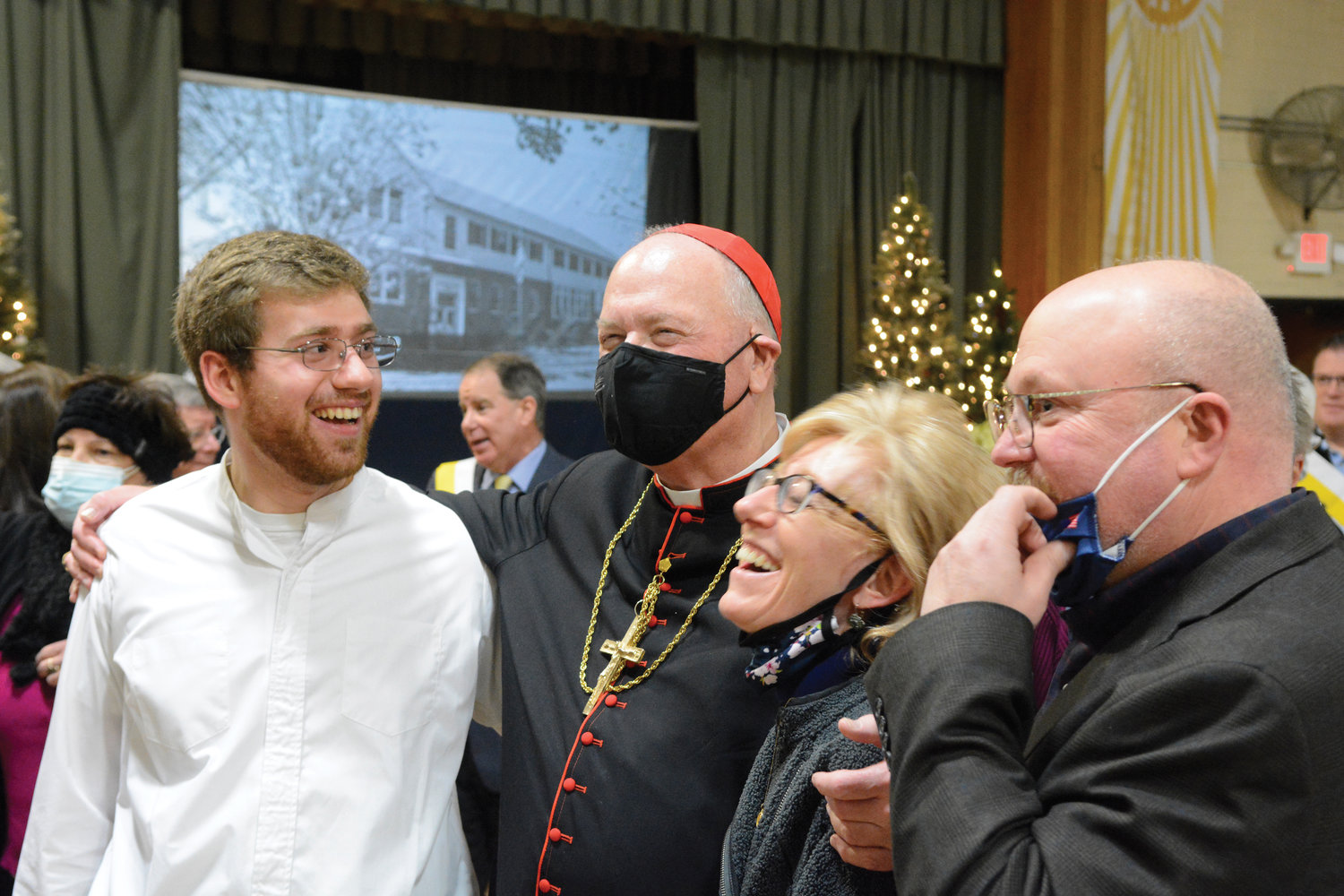 Altar server Jack Kristensen, left, a fourth-year college seminarian at The Catholic University of America in Washington, D.C., and his parents, Janine and Christian, meet Cardinal Dolan at a reception in the parish center after Mass.