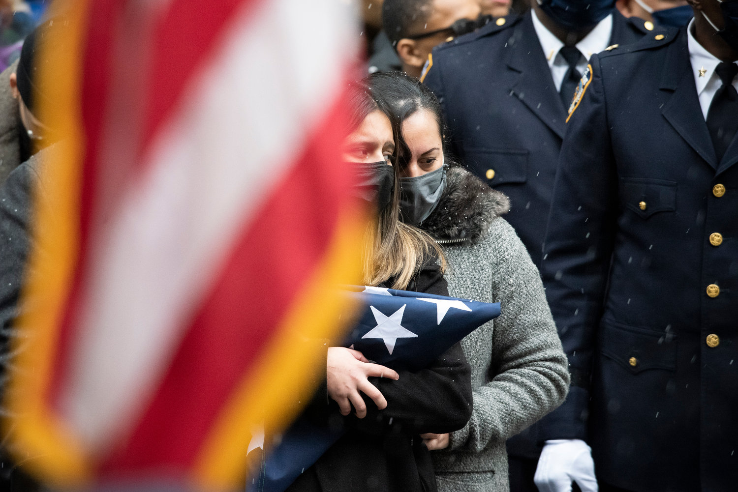 Det. Rivera’s widow, Dominique Luzuriaga, holds the folded flag presented to her outside St. Patrick’s Cathedral Jan. 28.