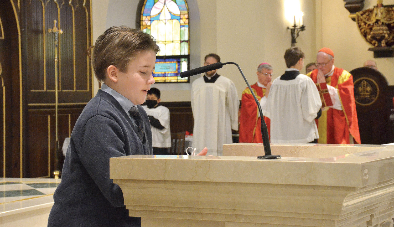 Holy Trinity sixth-grader Henry Kurz recites the prayer of the faithful during Mass celebrated by Cardinal Dolan at Holy Trinity Church in the Town of Poughkeepsie.