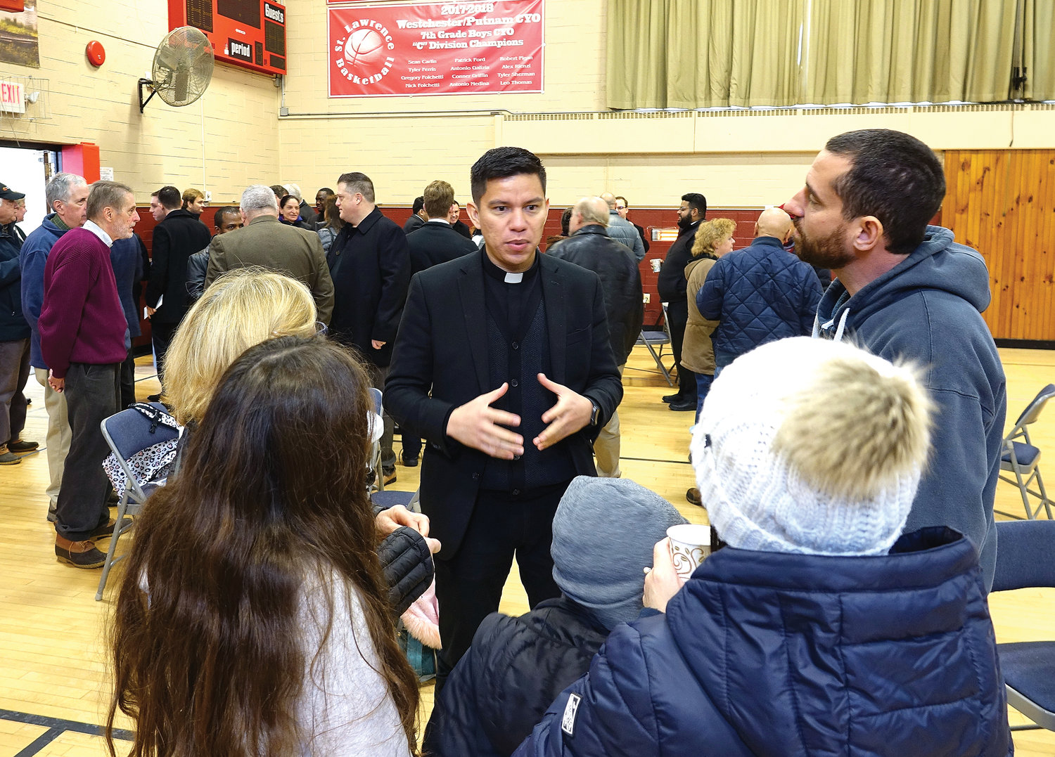 Seminarian Herley Mendez talks with parishioners at a meet and greet after Mass in the parish gymnasium.