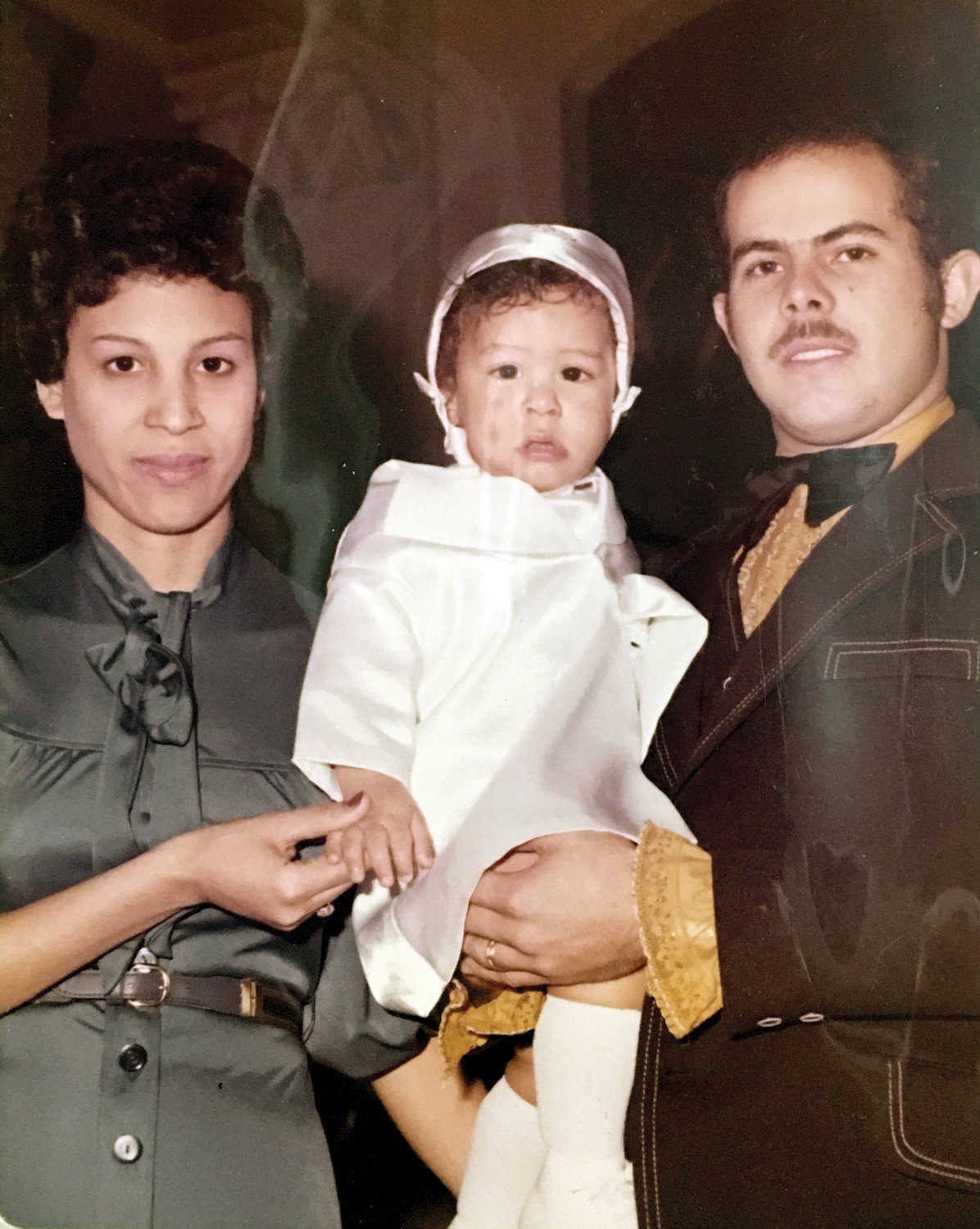 His parents Jose and Mercedes hold their young son after his baptism.