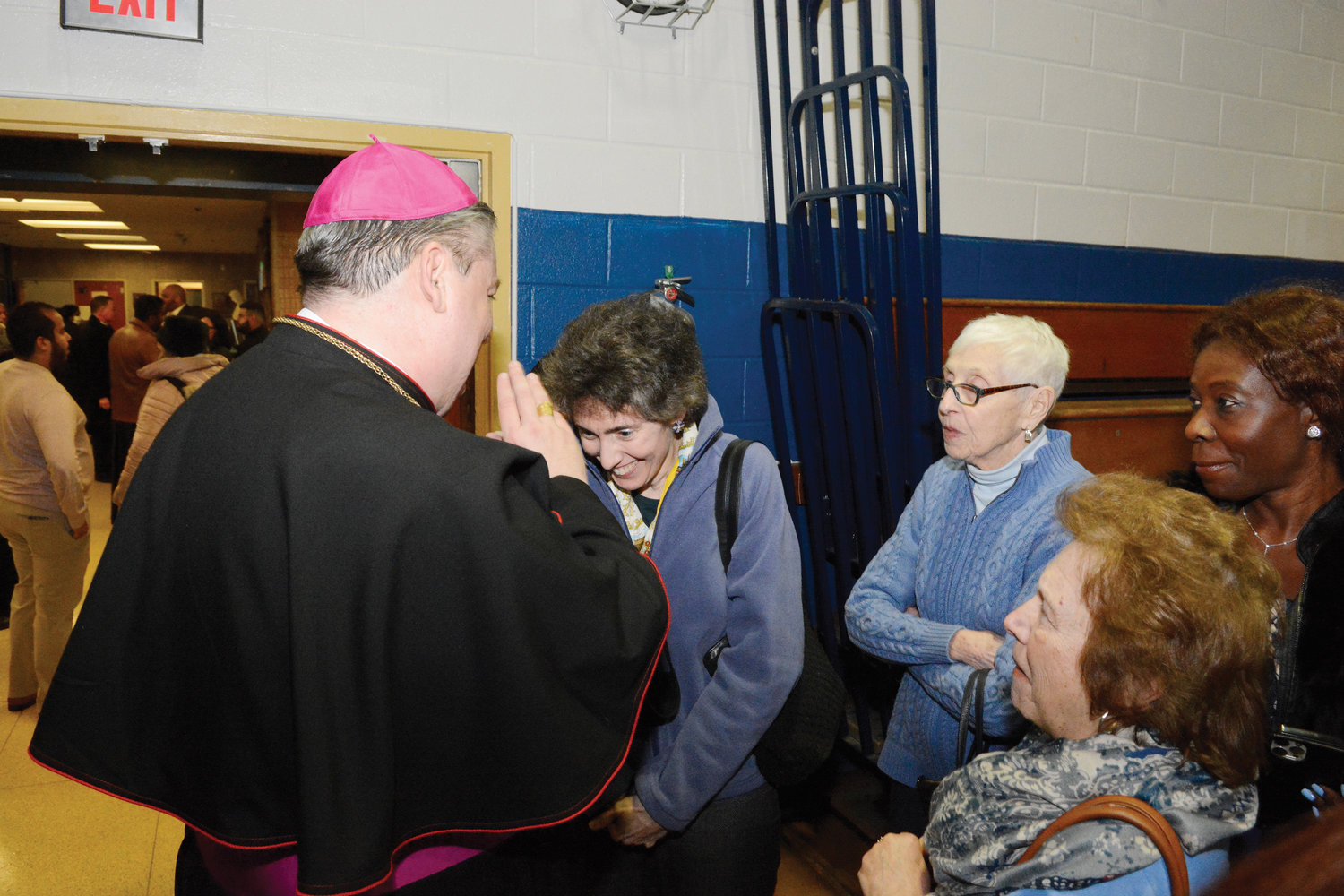 A woman happily receives a blessing from Bishop Bonnici.