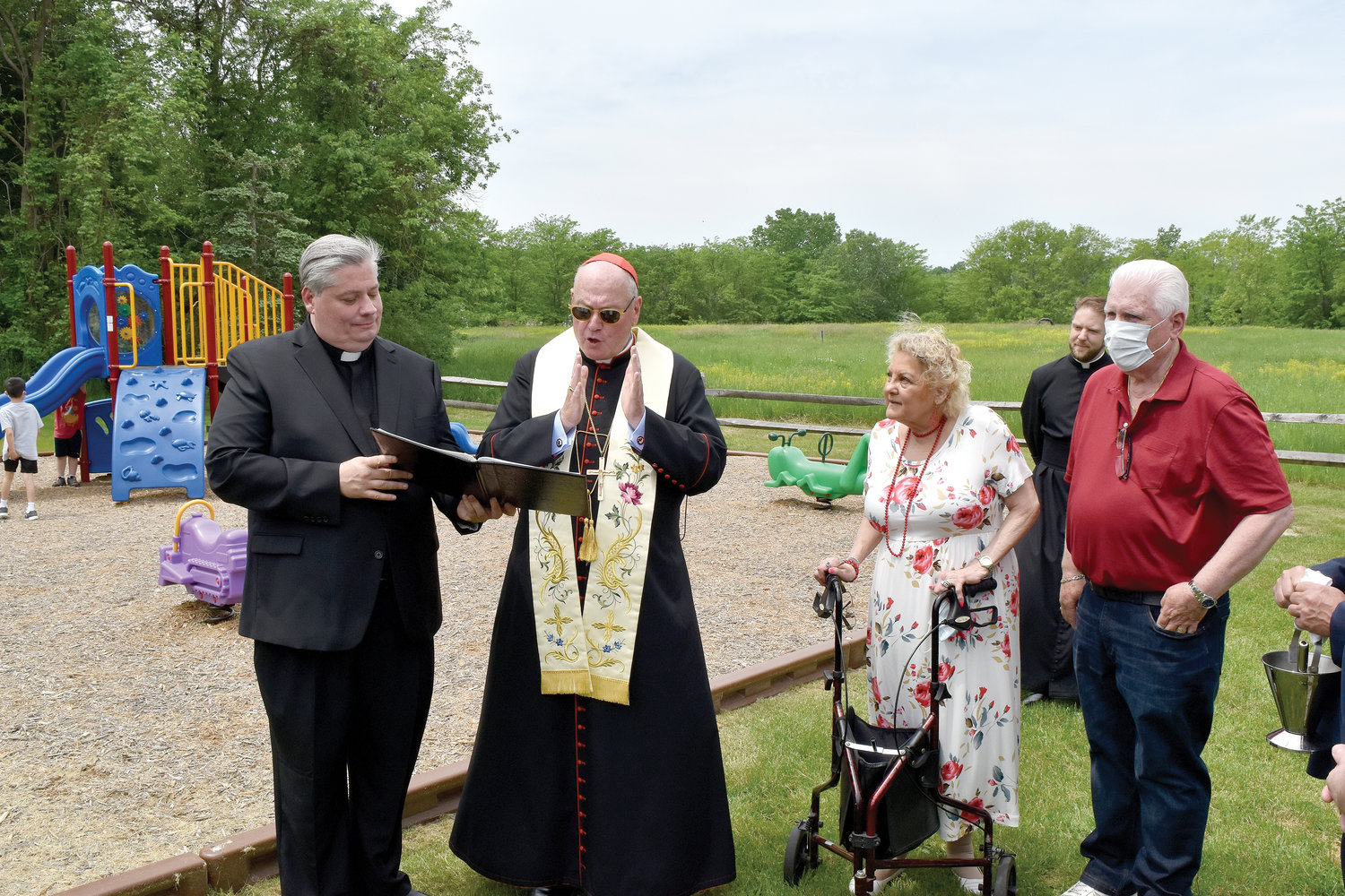 The new bishop joins Cardinal Dolan for the blessing of the Faith First Early Childhood Program playground at St. Columba’s parish in Chester last May.