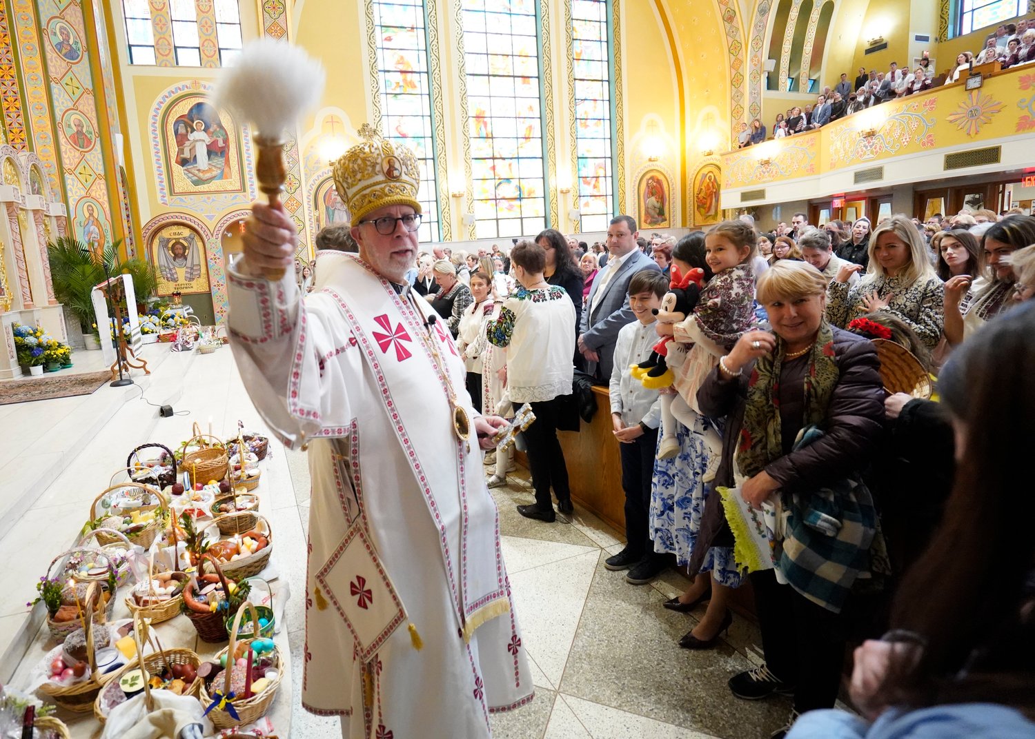 Bishop Paul P. Chomnycky of the Ukrainian Catholic Eparchy of Stamford, Conn., uses holy water to bless the congregation during an Easter Divine Liturgy April 24 at St. George Ukrainian Catholic Church in Manhattan’s East Village. The parish maintains many of its ancestral faith traditions, including celebrating services according to the Julian calendar.