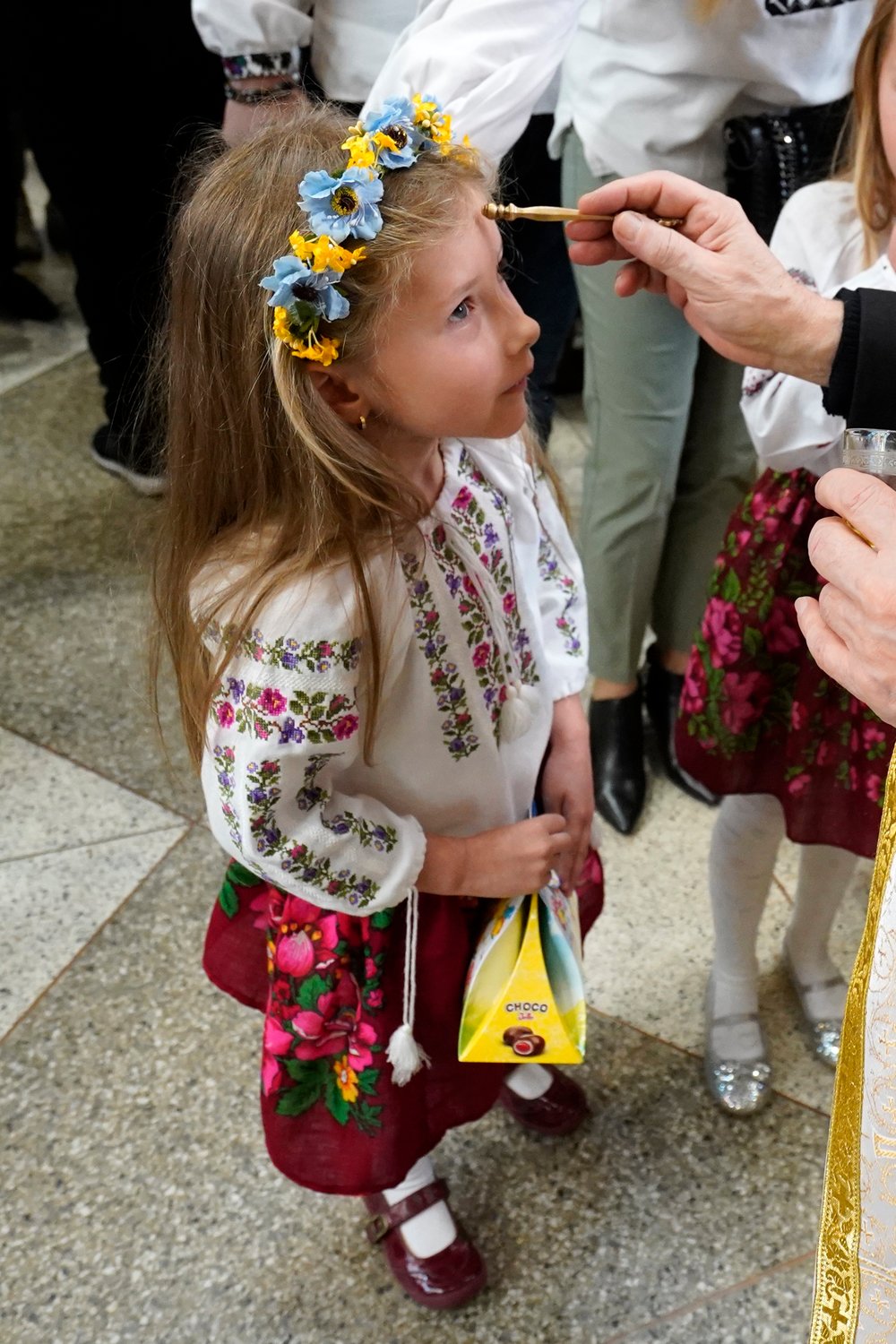 A priest blesses a girl with holy oil following an Easter Divine Liturgy April 24 at St. George Ukrainian Catholic Church in Manhattan’s East Village.