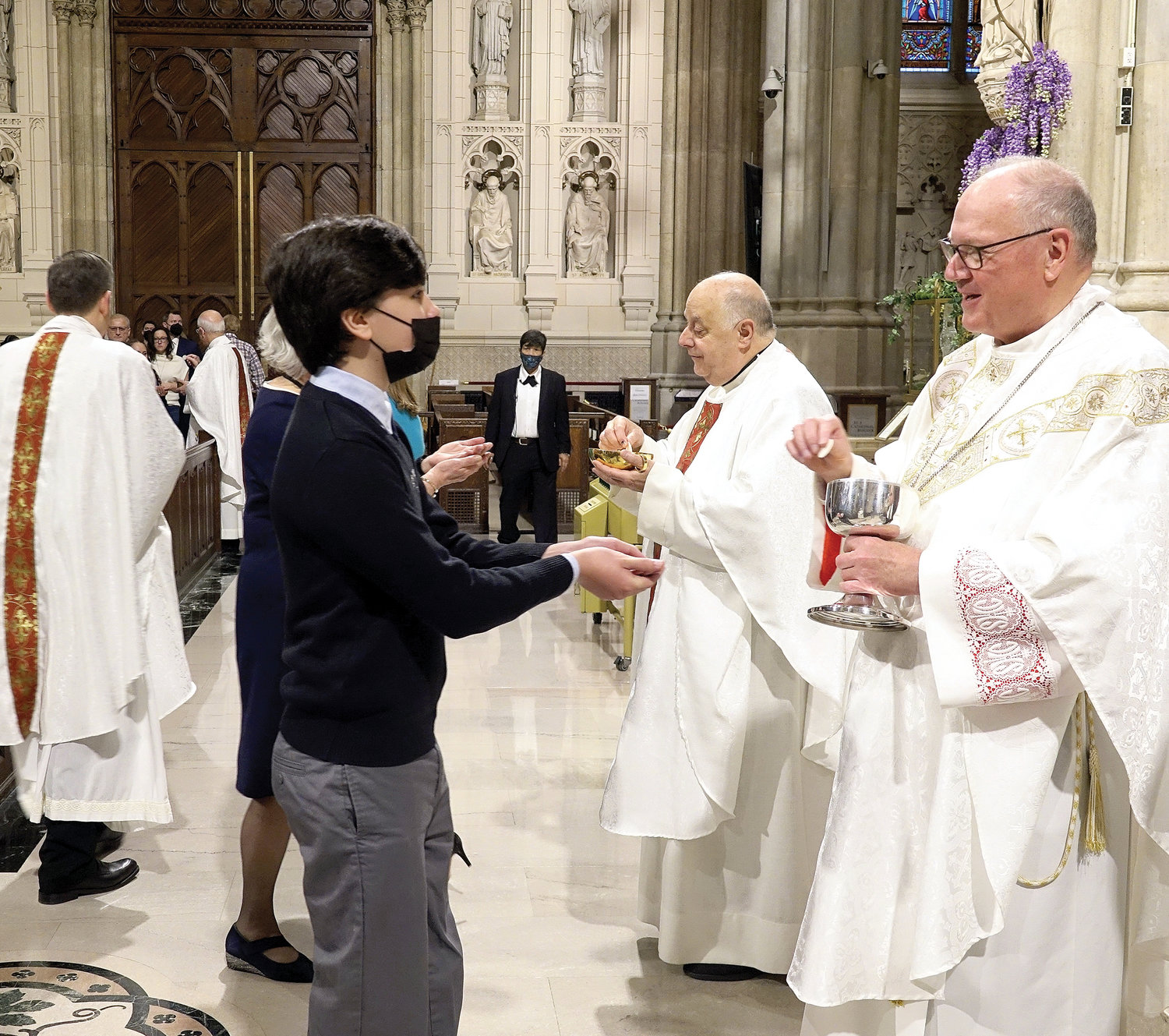 Cardinal Dolan and Msgr. Joseph LaMorte, vicar general and moderator of the curia in the archdiocese, distribute Communion at the Eighth-Grade Graduation Mass for Manhattan Region Catholic Schools in St. Patrick’s Cathedral on May 6.