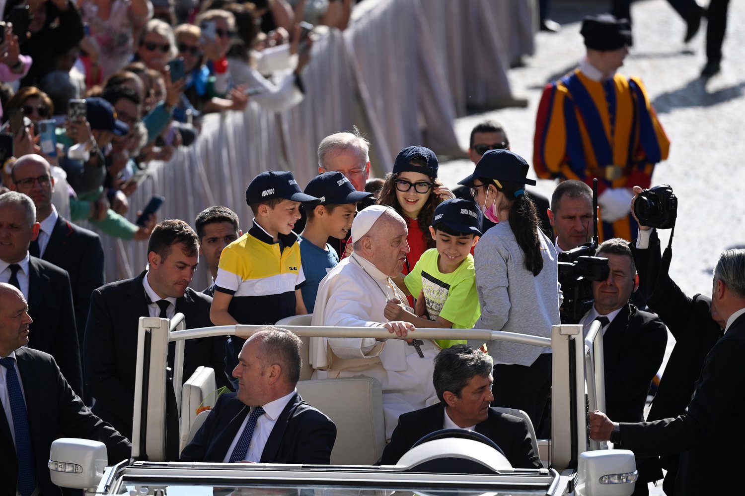 Pope Francis welcomes youngsters to take a ride with him in the popemobile at the beginning of his weekly general audience May 11 in St. Peter’s Square at the Vatican.
