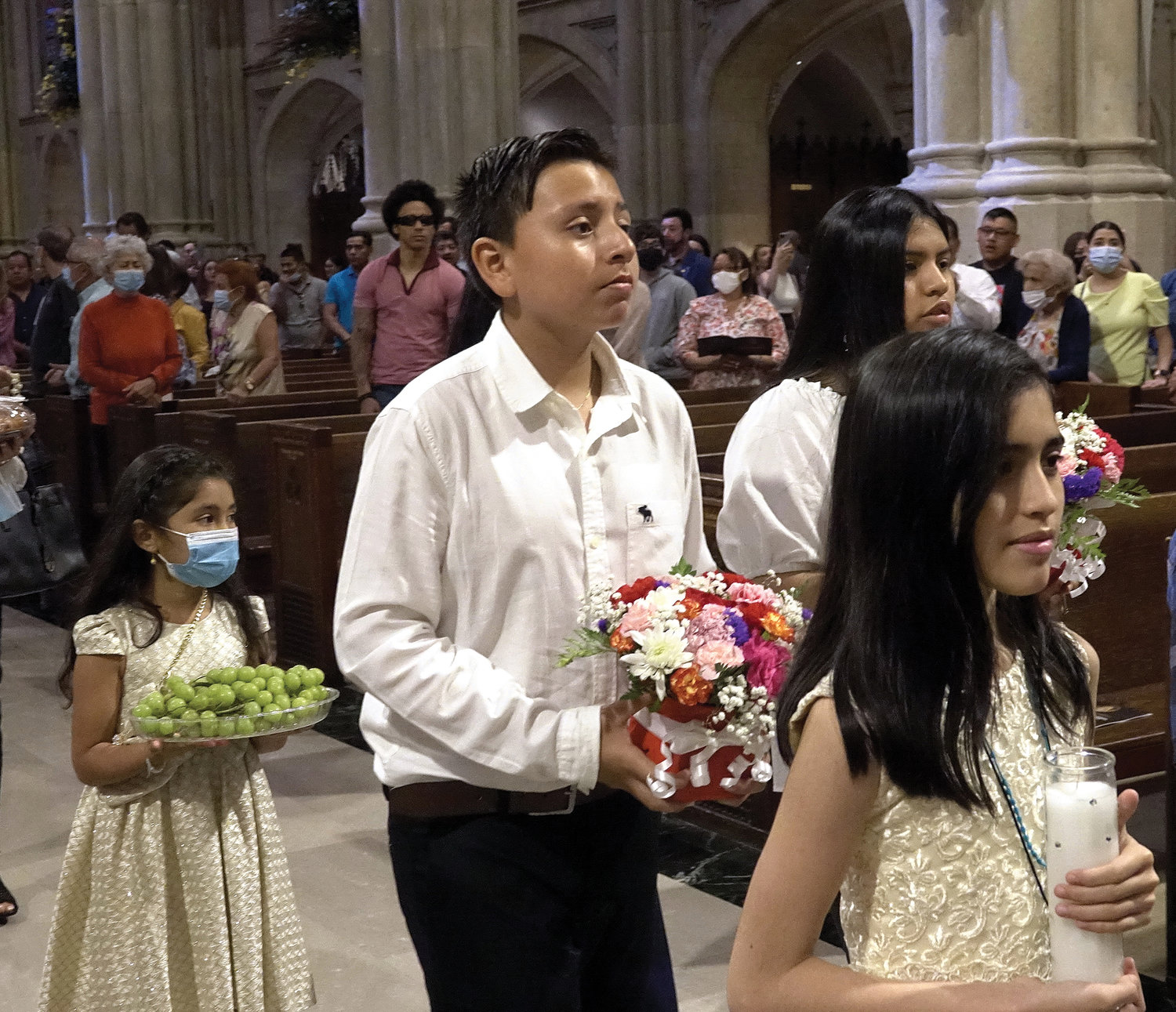 Youths take part in the entrance procession. Father Ato is communications director of the archdiocesan Office of Hispanic Ministry, and pastor of Sacred Heart parish in Manhattan.