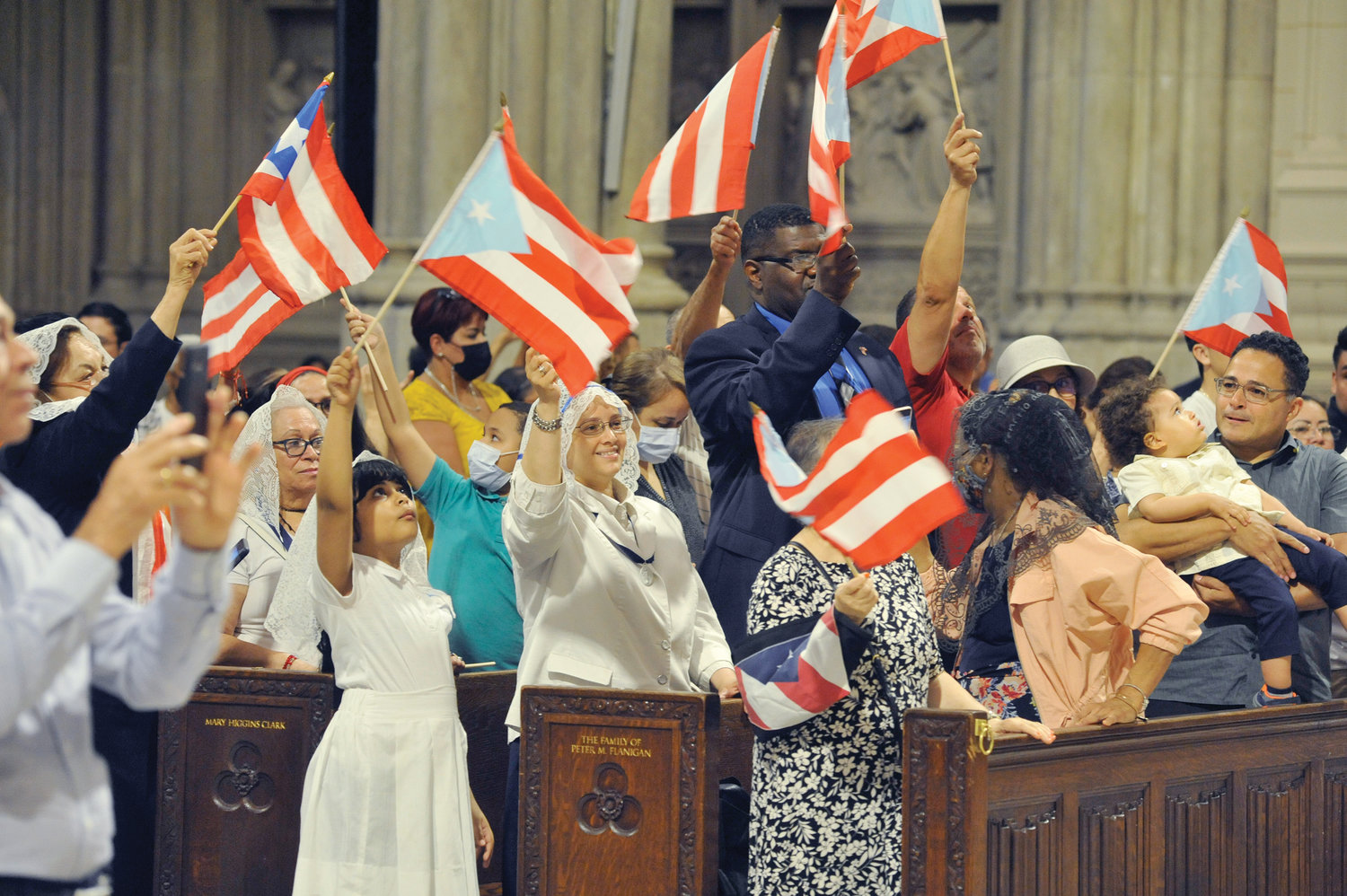 Banderas ondeando abunda en las bancas delanteras después de la Misa de la Herencia Cultural Puertorriqueña en la Catedral de San Patricio el 5 de junio.