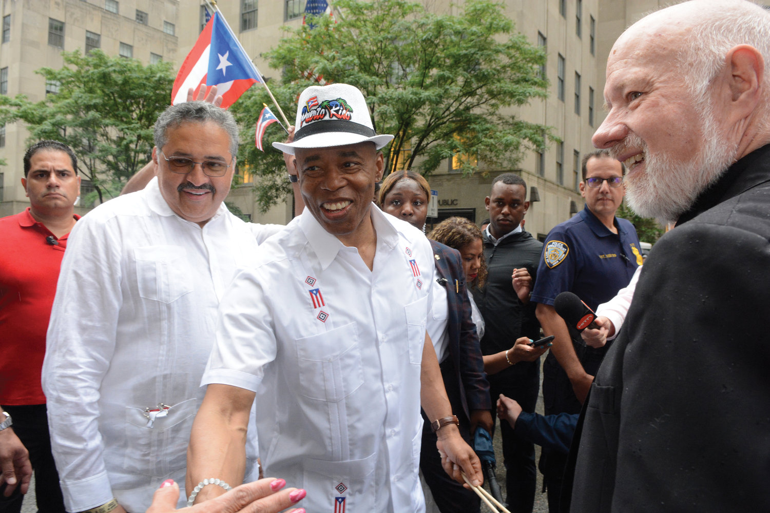 El alcalde Eric Adams de New York y Msgr. Kevin Sullivan, director ejecutivo de Caridades Católica arquidiocesano, comparten un momento de sonrisa durante el Desfile del Día de Puerto Rico el 12 de junio en la Quinta Avenida.
