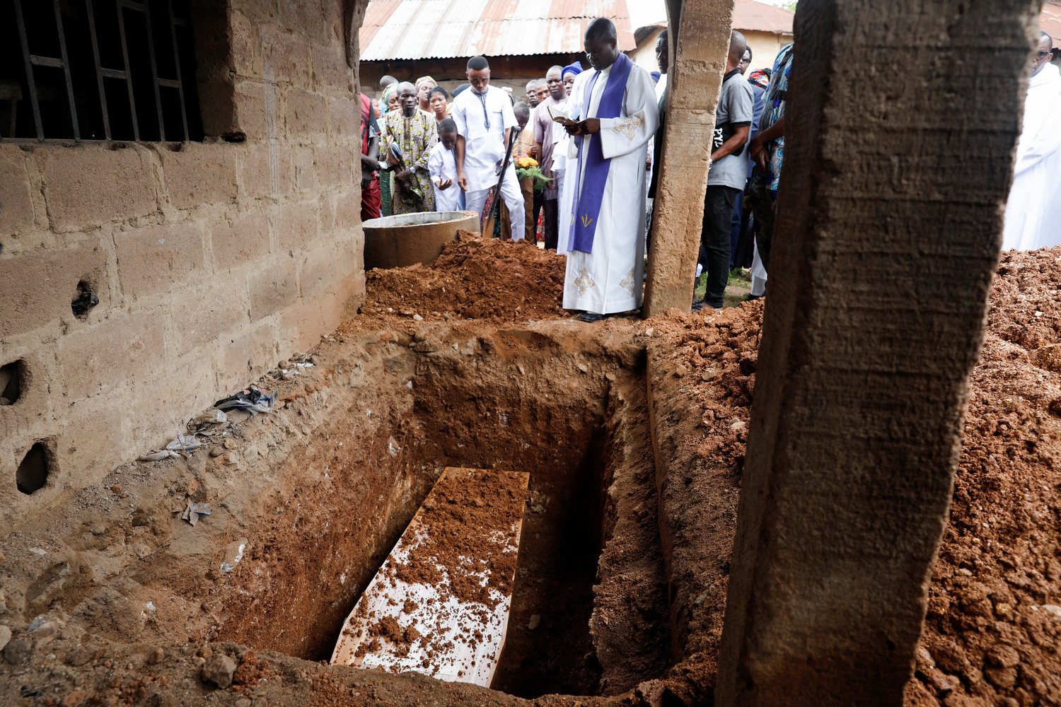 A priest prays over a casket during a burial outside St. Francis Xavier Church in Owo, Nigeria, June 17. The Funeral Mass was for at least 50 victims killed in a June 5 attack by gunmen during Mass at the church.