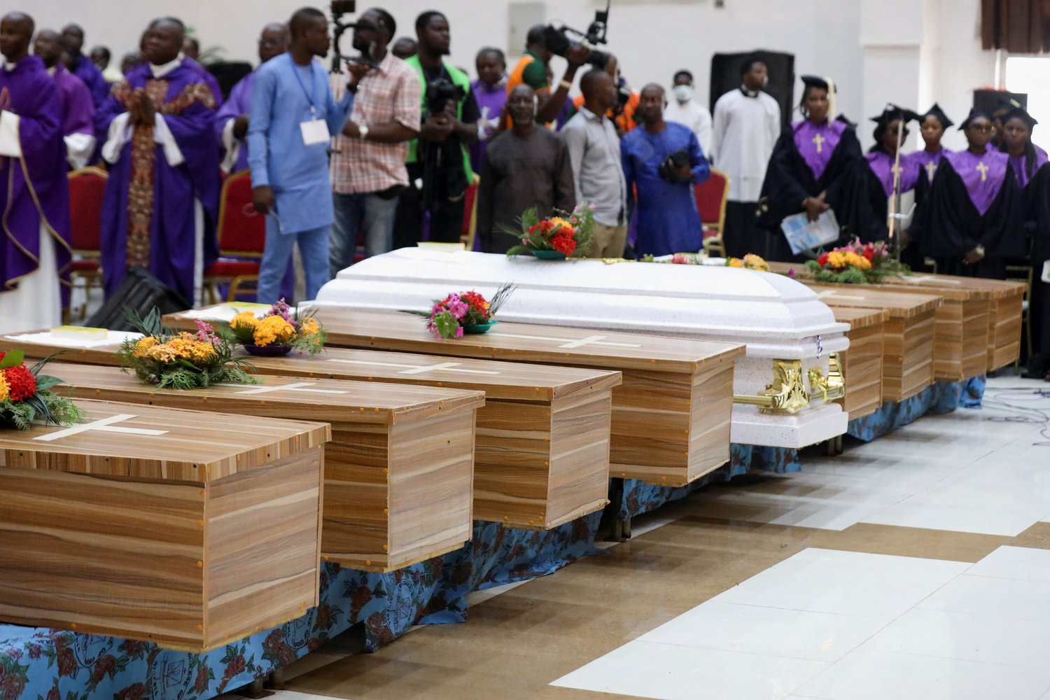 Flowers lie on caskets during a Funeral Mass in the parish hall of St. Francis Xavier Church in Owo, Nigeria, June 17.