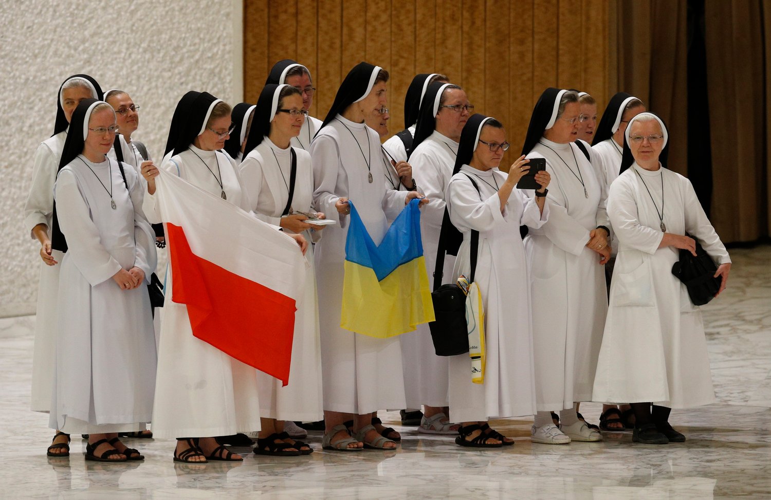 Nuns hold the national flags of Poland and Ukraine as they prepare to greet Pope Francis during his general audience in the Paul VI hall at the Vatican Aug. 3.