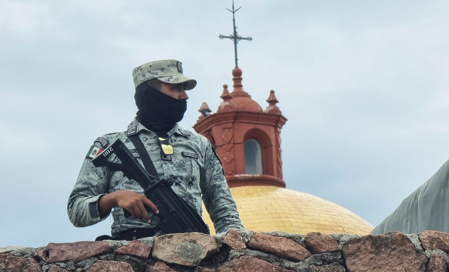 A member of the Mexican army stands guard outside a church in the parish community of Cerocahui June 22. Jesuit Fathers Javier Campos Morales and Joaquín César Mora Salazar were murdered at the parish June 20 as they offered refuge to a tour guide seeking protection.