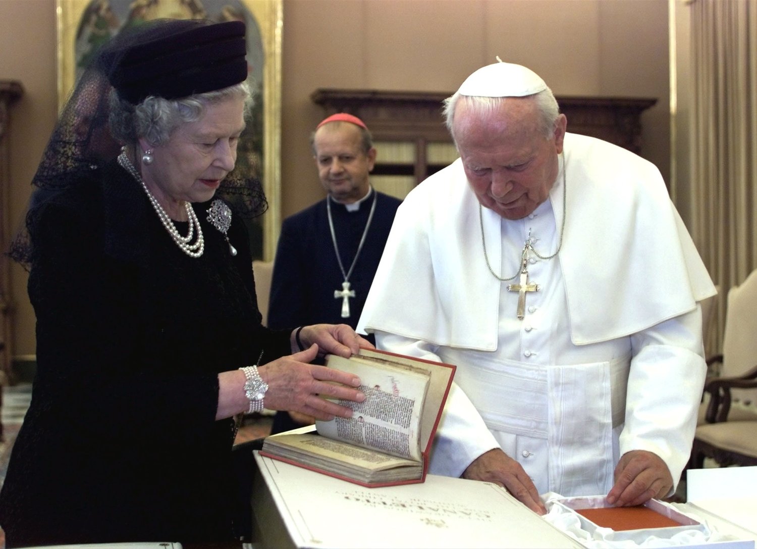 Pope John Paul II exchanges gifts with Britain’s Queen Elizabeth II during their private audience at the Vatican Oct. 17, 2000.