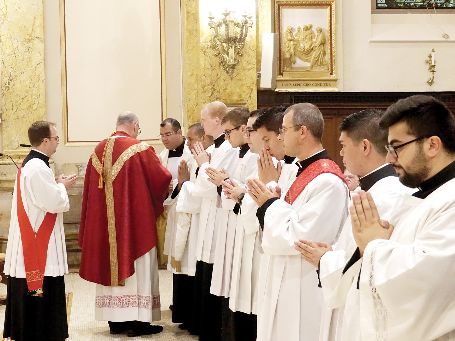 The cardinal distributes Communion to the seminarians.