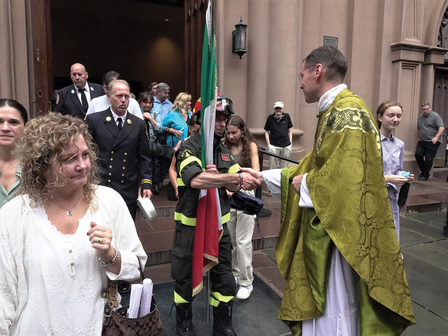 The pastor, Father Brian Graebe, who celebrated the Mass, greets a firefighter afterward.