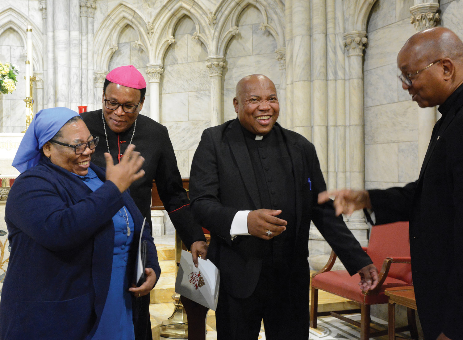 Bishop Dumas enjoying a light moment with Father Emile and his sister, Sister Alta Emile, C.D.J., of Haiti, and Brother Tyrone Davis, C.F.C., executive director of the archdiocesan Office of Black Ministry.