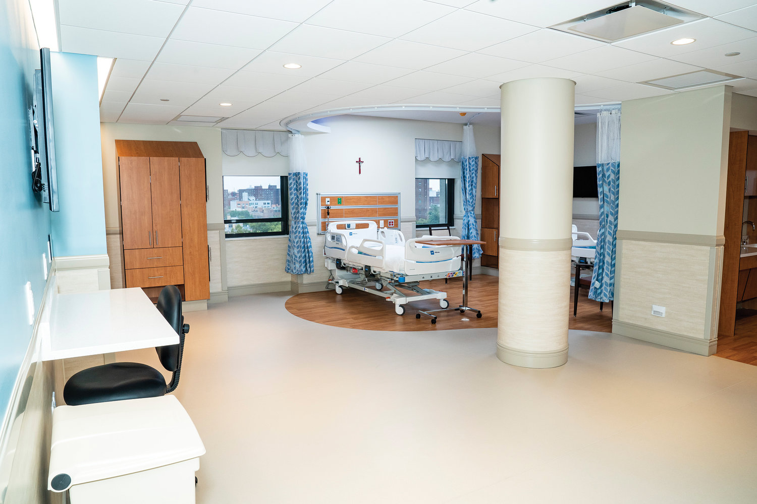 A crucifix graces the wall above a technology-enabled bed in a spacious room at the newly renovated hospital.