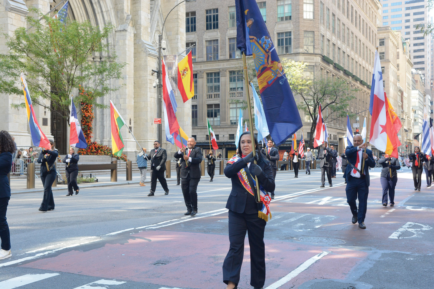 Banderas latinoamericanas abundan mientras participantes pasan la Catedral de San Patricio durante el desfile anual del Día de la Hispanidad NYC el 9 de octubre en la Quinta Avenida.