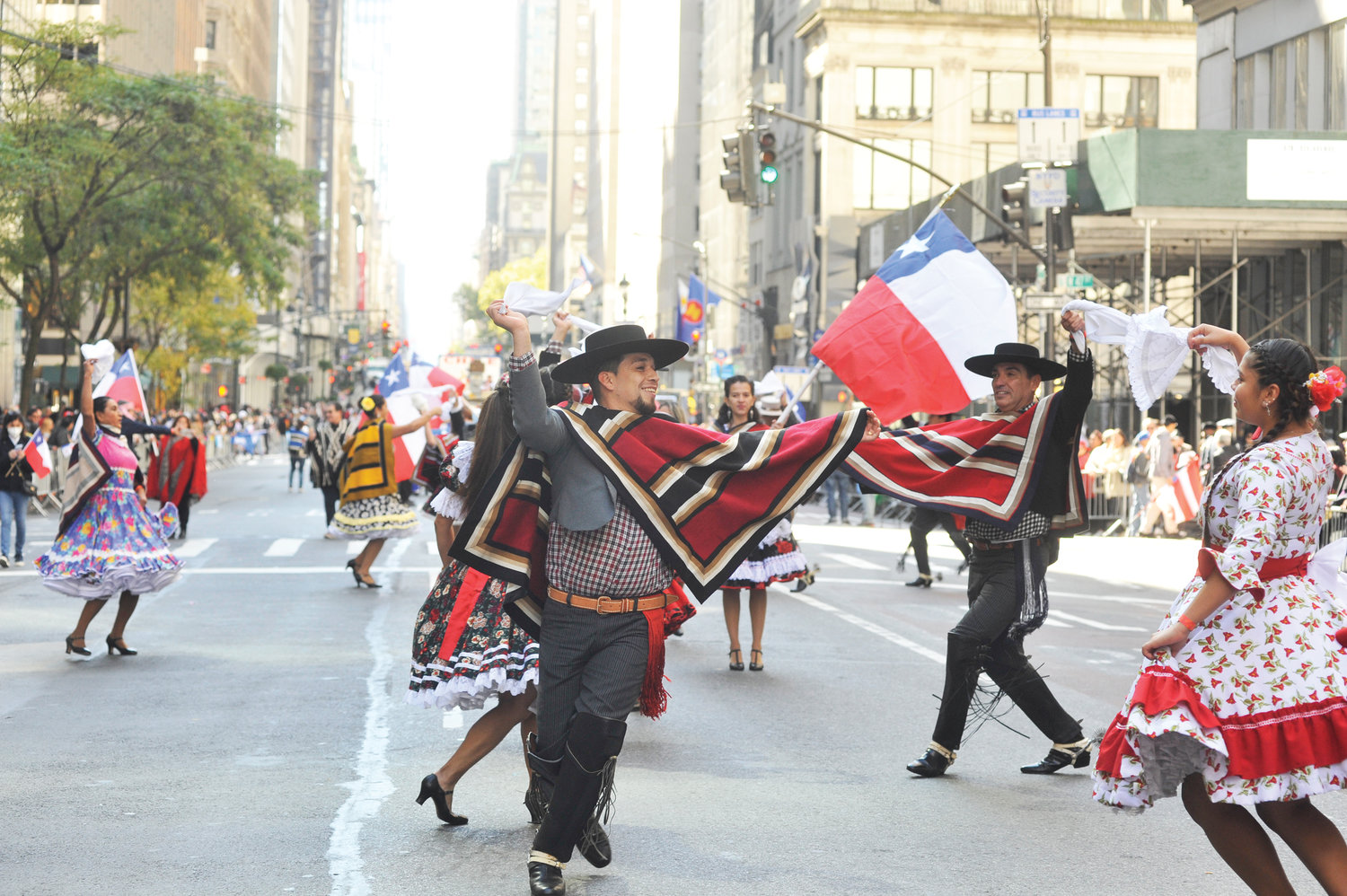 Participantes vestidos de muchos colores marchan en la Quinta Avenida en Manhattan el 9 de octubre durante el desfile anual del Día de la Hispanidad NYC.
