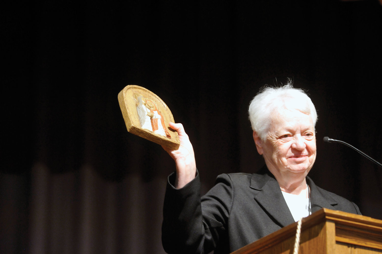 Sister Joan Curtin, C.N.D., holds up the Magnificat Award named in her honor that she received Oct. 15 at the annual forum for catechesis and youth ministry.  Now the vicar for religious in the archdiocese, Sister Joan was the director of archdiocesan Catechetical Office for more than three decades.