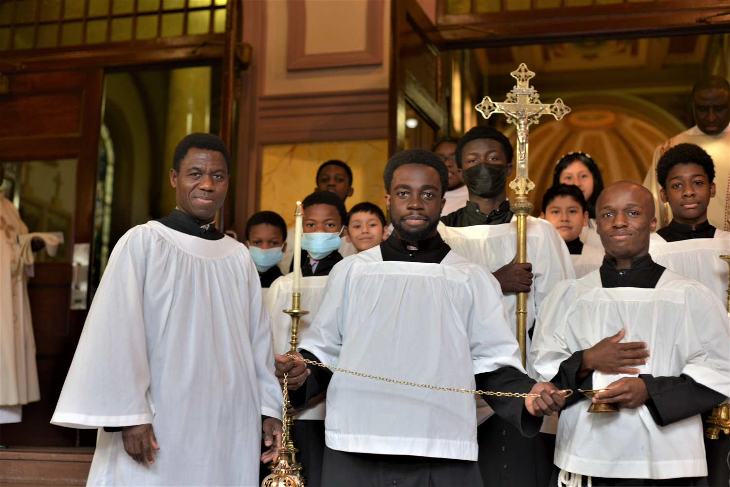 A group photo features a number of altar servers.